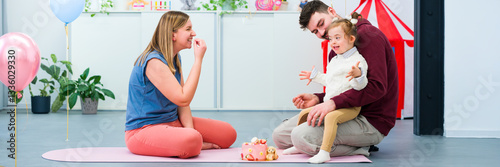 Nonverbal child with Down syndrome learning baby sign language with the help of a speech therapist and her father. Neurodiversity, learning difficulty, developmental disability. photo