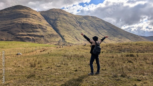Obraz na płótnie Beautiful woman backpacker in hooded jacket hiking at river Erriff near Aesleagh, county Mayo, Ireland, Irish landscape, mountains and nature background w salonie