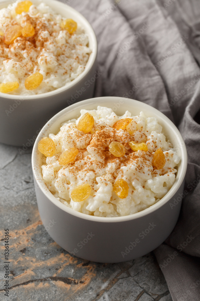 Delicious rice pudding with cinnamon, vanilla and raisins closeup on the bowl on the table. Vertical