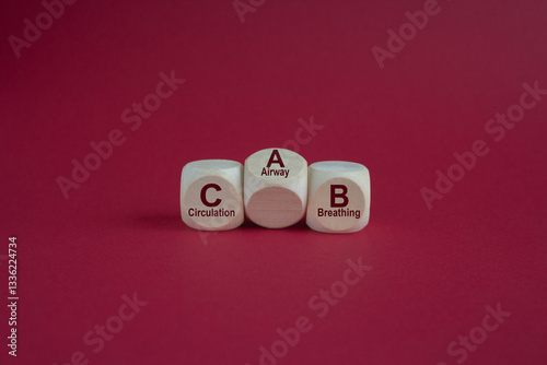 Dices form the acronym CAB (Circulation, Airway, Breathing). Beautiful red background. Symbol for basic life support.