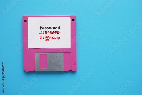 Floppy disk on blue background with very weak and easy to guess password written - replaced to strong and more secure password
