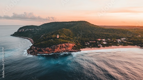 Aerial view of a coastal landscape at sunset featuring ocean and land