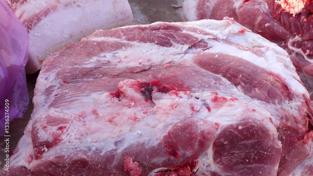 A piece of meat lies on a market counter. A piece of meat lies on a market counter.
