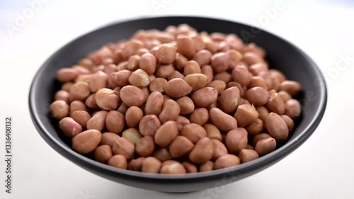 Spinning Bowl of Raw Peanuts. A Close-Up Look at Nature Crunchy Snack