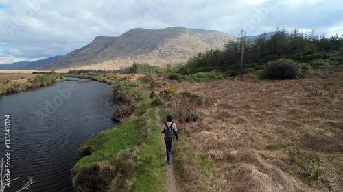 Woman backpacker hiking on trail by the Erriff river near Aesleagh falls, county Mayo, Ireland, aerial, Irish landscape, nature and mountains photo