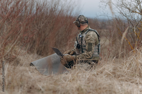 Obraz na płótnie Soldier Analyzing Data in Natural Surroundings