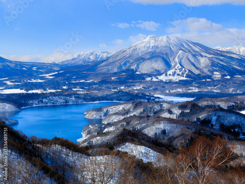 Breathtaking alpine scenery with snow-capped volcano and lake with blue sky
