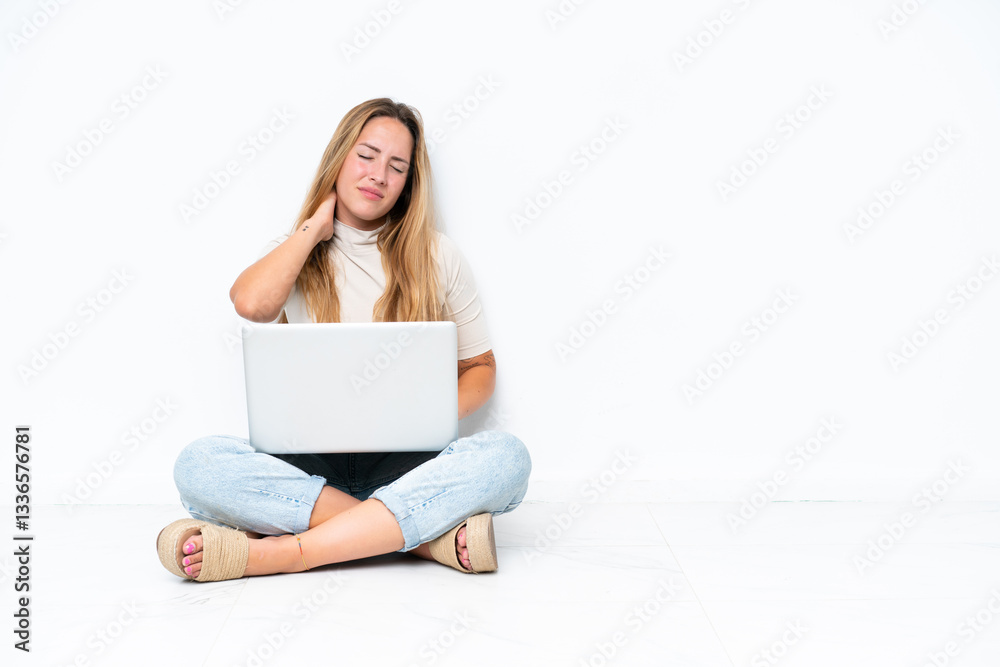 Fototapeta premium Young woman with laptop sitting on the floor isolated on white background with neckache
