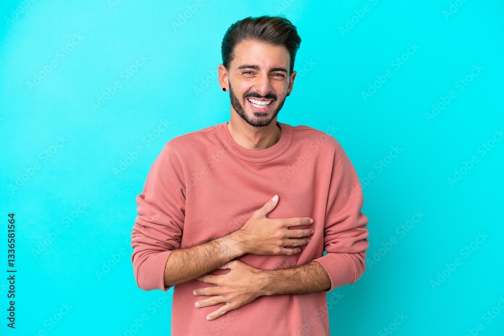 Fototapeta premium Young caucasian man isolated on blue background smiling a lot