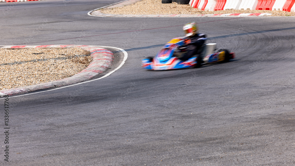 Fototapeta premium Motion blur kart driver drive go kart on kart race track circuit, Go kart racer driver on curve race track, Extreme sport .