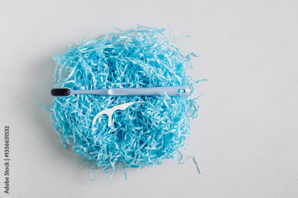 Toothbrush and disposable toothbrush on gift wrap filler top view