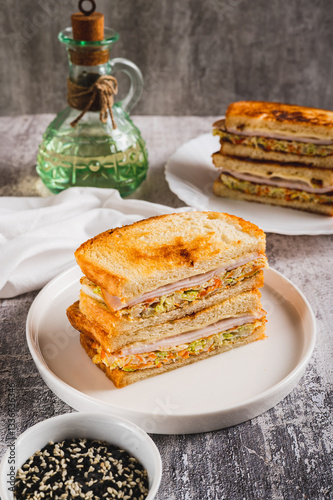 Obraz na płótnie Korean street sandwich with cabbage, ham and cheese on plate on table vertical view w salonie