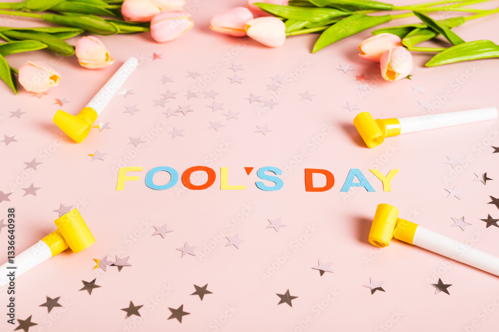 April Fools' Day written in colored letters, whistles, stars and tulips on pink
