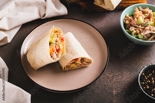 Obraz na płótnie Shawarma in pita bread with meat and vegetables on a plate on the table w salonie