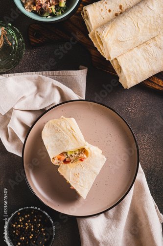 Obraz na płótnie Shawarma in pita bread with meat and vegetables on a plate on the table top and vertical view w salonie