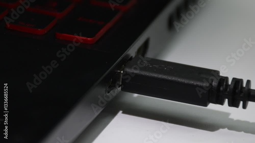 Connecting a USB cable to a computer, hand plugging device into USB port. High quality 4k footage