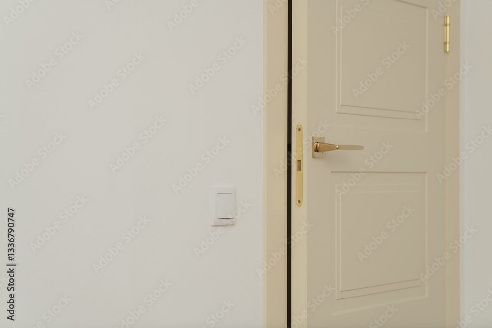 A simple interior door is partially open, revealing a light and airy space. The warm beige tone of the door complements the neutral wall, enhancing the minimalist aesthetic A simple interior door is partially open, revealing a light and airy space. The warm beige tone of the door complements the neutral wall, enhancing the minimalist aesthetic