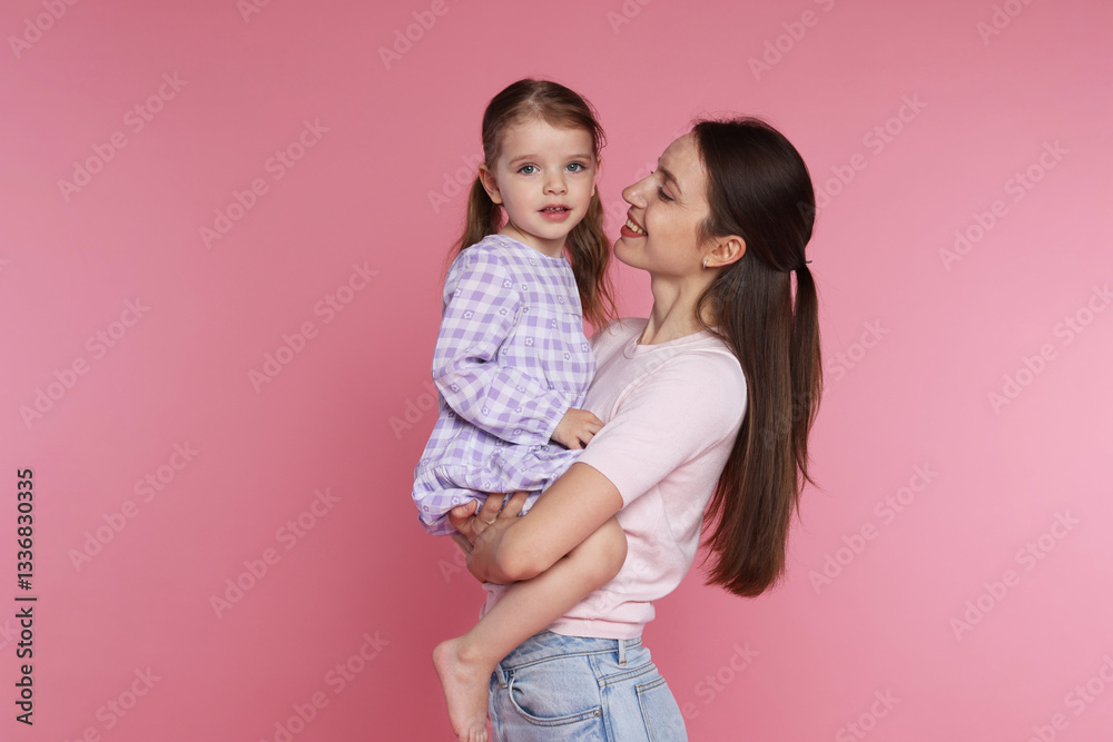 Happy mother with her cute little daughter on pink background Happy mother with her cute little daughter on pink background