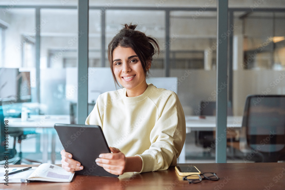 Portrait of middle eastern student or worker using tablet pc financial application standing in office. Smiling indian or latin hispanic business woman holding digital pad computer, looking at camera. Portrait of middle eastern student or worker using tablet pc financial application standing in office. Smiling indian or latin hispanic business woman holding digital pad computer, looking at camera.