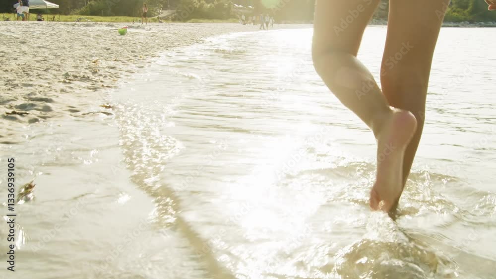 A Young Girl Runs Barefoot Across A Sandy Beach, Leaving Footprints In The Soft Sand As The Sun Sets Over The Ocean. This Peaceful Moment Reflects The Joy Of Summer Travel And Family Holidays. A Young Girl Runs Barefoot Across A Sandy Beach, Leaving Footprints In The Soft Sand As The Sun Sets Over The Ocean. This Peaceful Moment Reflects The Joy Of Summer Travel And Family Holidays.