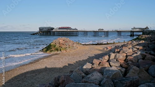 Wallpaper Mural View across the beach towards the Victorian pier in the seaside town of Cromer on the North Norfolk Coast. Captured on a sunny afternoon as the sun starts to set. Static camera shot. Torontodigital.ca