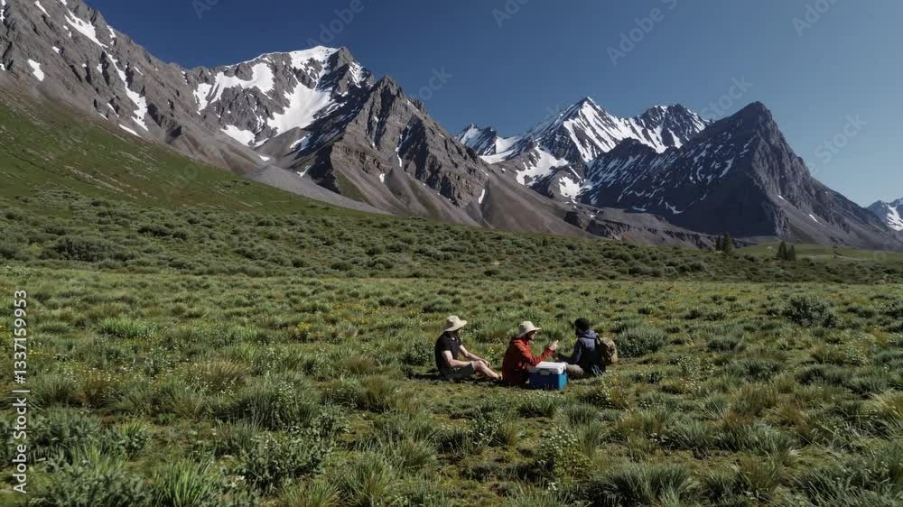 Friends Enjoying a Relaxing Picnic Amidst Majestic Mountain Landscape Friends Enjoying a Relaxing Picnic Amidst Majestic Mountain Landscape