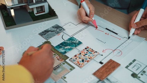 A team collaborates on an interior design project, sketching a floor plan while using color swatches and samples to enhance their creative process and ideas. SACTR