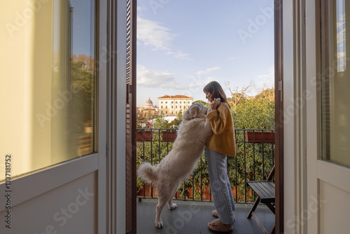 Obraz na płótnie A young woman in cozy loungewear embraces her fluffy white dog on a balcony with a stunning view of Vatican City in Rome. A peaceful morning moment filled with warmth, love, and Italian charm w salonie