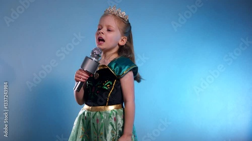 A little princess, voice soaring, a captivating performance. The Queen sings into the microphone and dances. Karaoke. Emerald gown, sparkling crown, a tiny starlet takes the stage. Hands clasped 