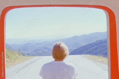 Un hombre mira hacia un paisaje montañoso a través de un marco rojo, evocando la sensación de tranquilidad y reflexión.