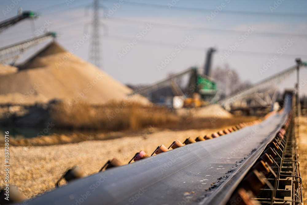 heavy duty conveyor belt - open pit mine and sand mining in the background - raw material transport