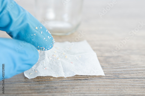 small particles of microplastics collected in water in a filter by researcher, contamination of the environment and aquatic environment.