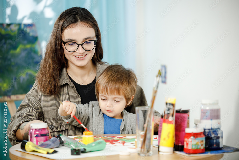 Fototapeta premium Mother and son painting together in their room