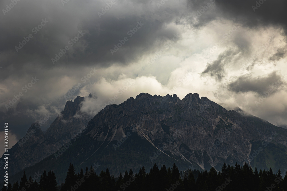 alte catene montuose nell'Italia settentrionale, in Veneto, nell'oscurità, sotto un cielo coperto da nuvole scure e cariche di pioggia, all'arrivo di un temporale estivo