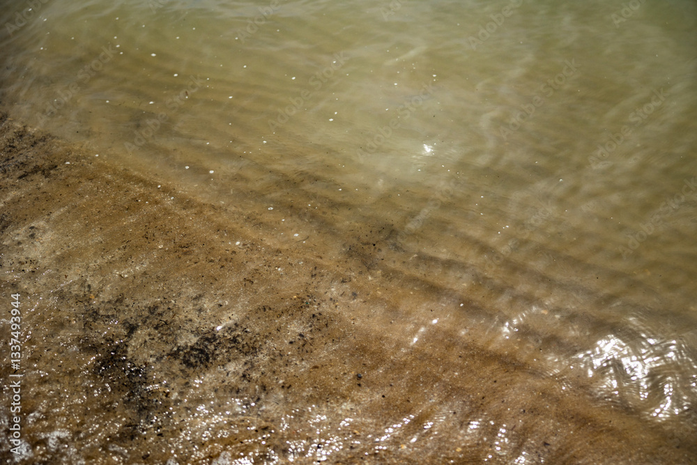 dettagli del tratto di mare dove l'acqua bagna la sabbia della spiaggia