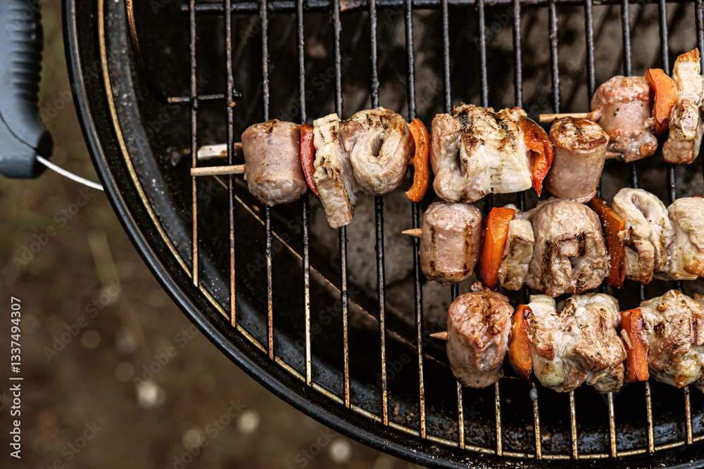 spiedini di carne e peperoni mentre vengono cucinati su una griglia