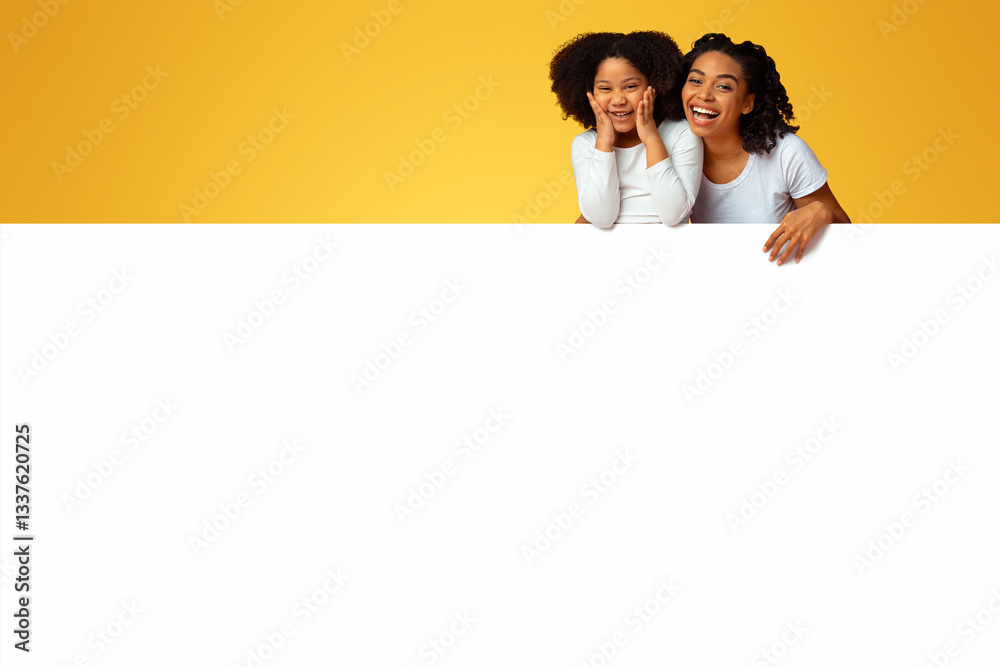 Amazing Offer. Overjoyed Black Mom And Little Daughter Leaning On White Advertisement Board With Free Space For Your Text Amazing Offer. Overjoyed Black Mom And Little Daughter Leaning On White Advertisement Board With Free Space For Your Text