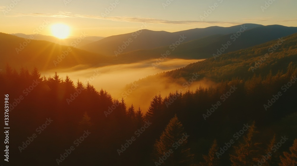 Naklejka premium Aerial view of misty mountains at sunrise with golden light casting over rolling peaks, creating a breathtaking and tranquil natural landscape.