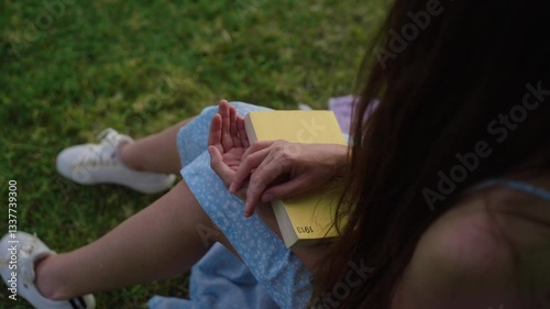 close-up shot of the hands of a girl who keeps a yellow book.