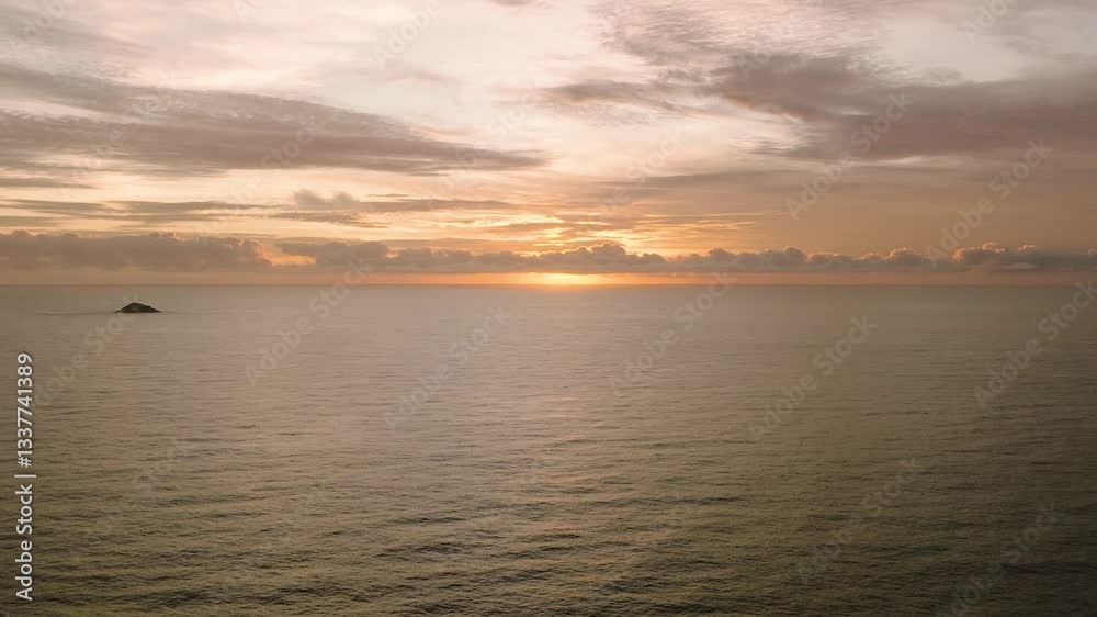 A tranquil sunset over the calm ocean with soft clouds on the horizon and serene skies. Seychelles, Praslin. A tranquil sunset over the calm ocean with soft clouds on the horizon and serene skies. Seychelles, Praslin.