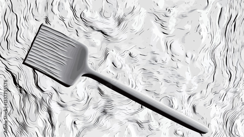 High-angle, close-up shot of a grey silicone spatula lying on a textured, wavy, white surface. The spatula is rectangular with evenly spaced ridges and a long handle. The image is in grayscale with