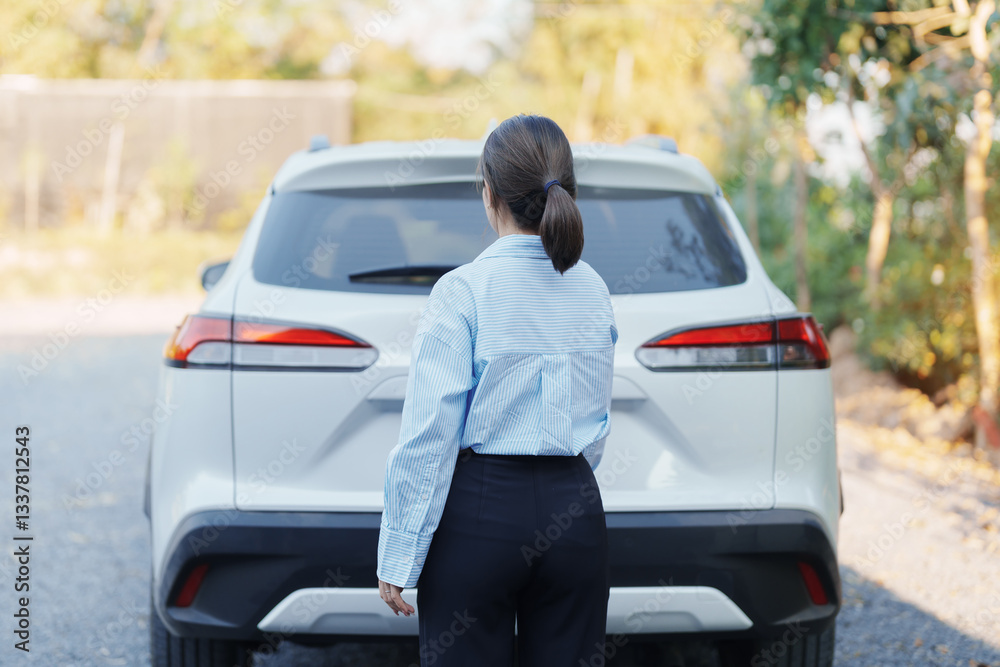 Hand holding car remote control, smart key to lock or unlock back door of white car. Safety, travel and transportation concept Hand holding car remote control, smart key to lock or unlock back door of white car. Safety, travel and transportation concept