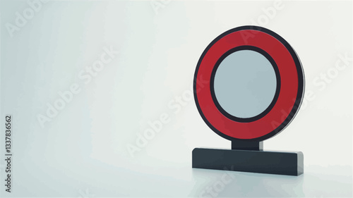 Close-up studio shot of a small, three-dimensional model of a red circle with a smaller white circle inside, set on a black rectangular base. The background is plain white. The image is sharply