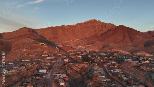 Drone footage of mountainous city at a calm sunrise with clear blue sky in El Paso, Texas, USA