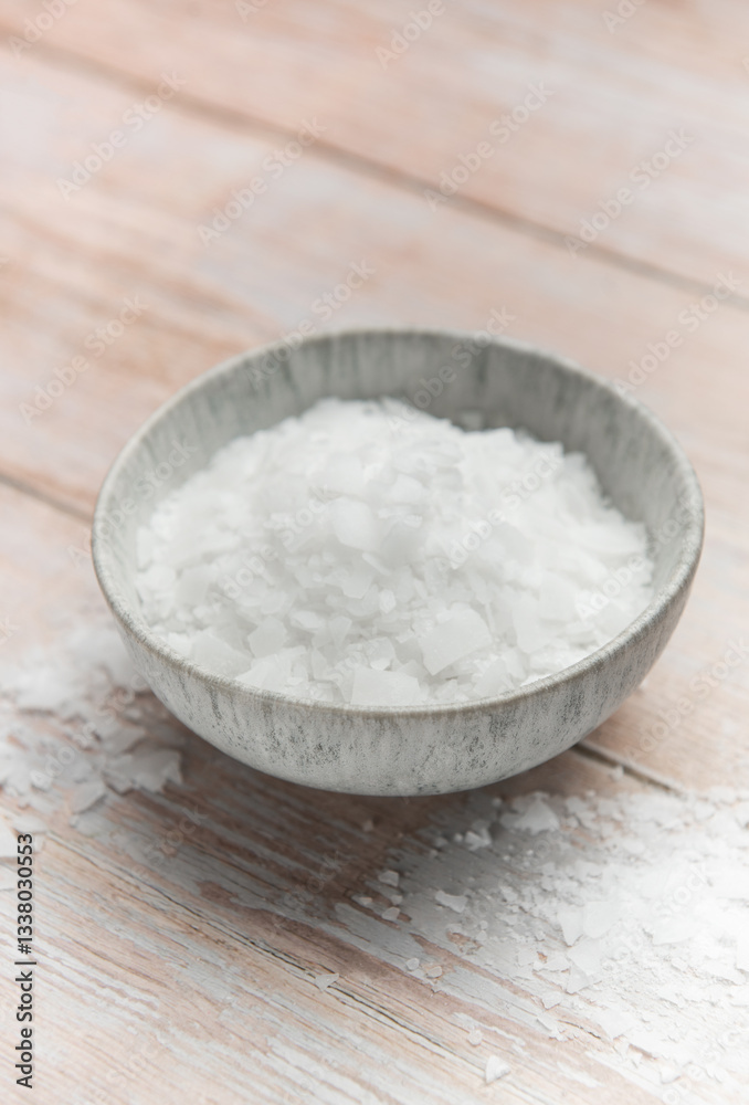 Magnesium chloride flakes in a bowl on rustic wooden table Magnesium chloride flakes in a bowl on rustic wooden table