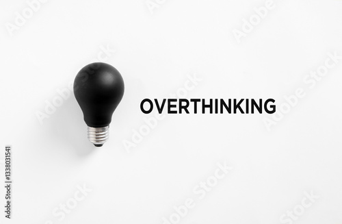 Black light bulb representing overthinking placed on white background