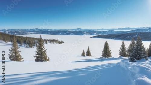 Fototapeta Naklejka Na Ścianę i Meble -  Snow-covered terrain in a mountain range under a clear blue sky on a warm sunny winter day.