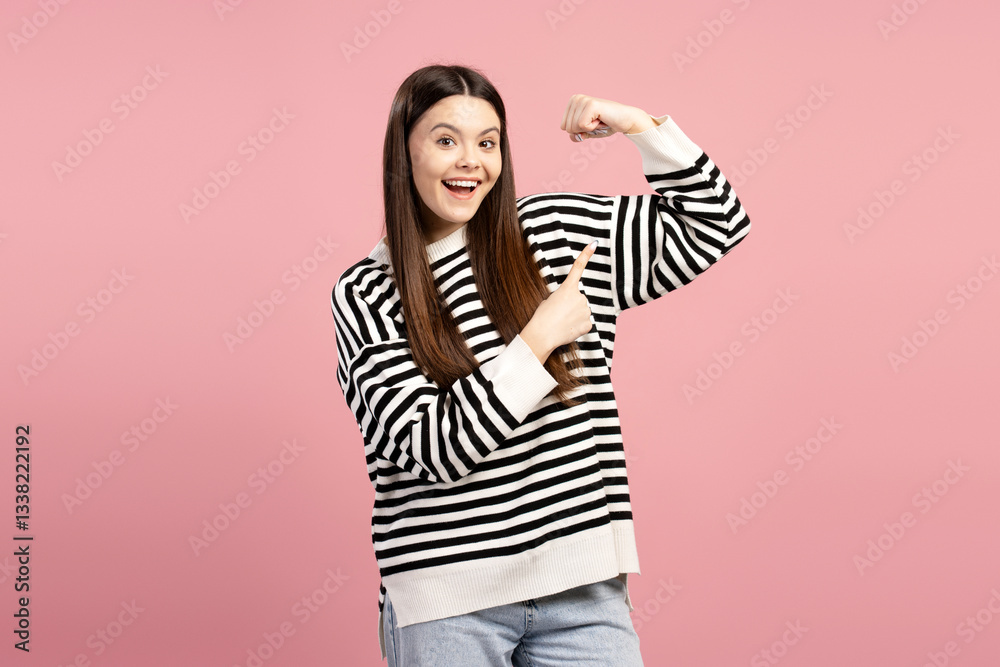 Young girl showing her biceps and pointing at it Young girl showing her biceps and pointing at it