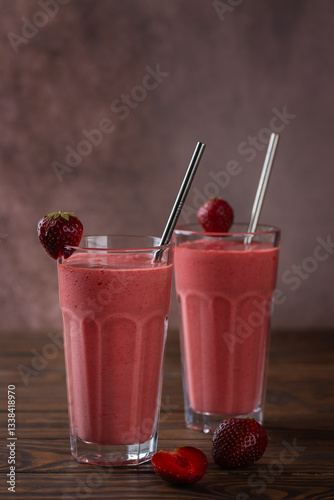 Strawberry smoothie or milkshake drink with coconut cream and green buckwheat on a wooden table. Lactose and sugar free. Vertical orientation.