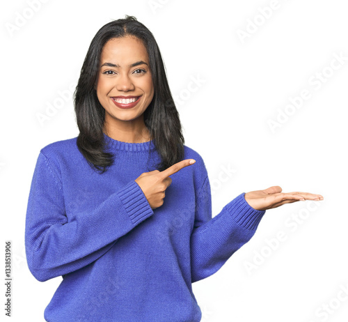 Simple portrait of a young Latina excited holding a copy space on palm.